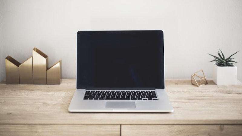 Laptop open on a plain wooden desk, a typical setup for cheap laptops for students