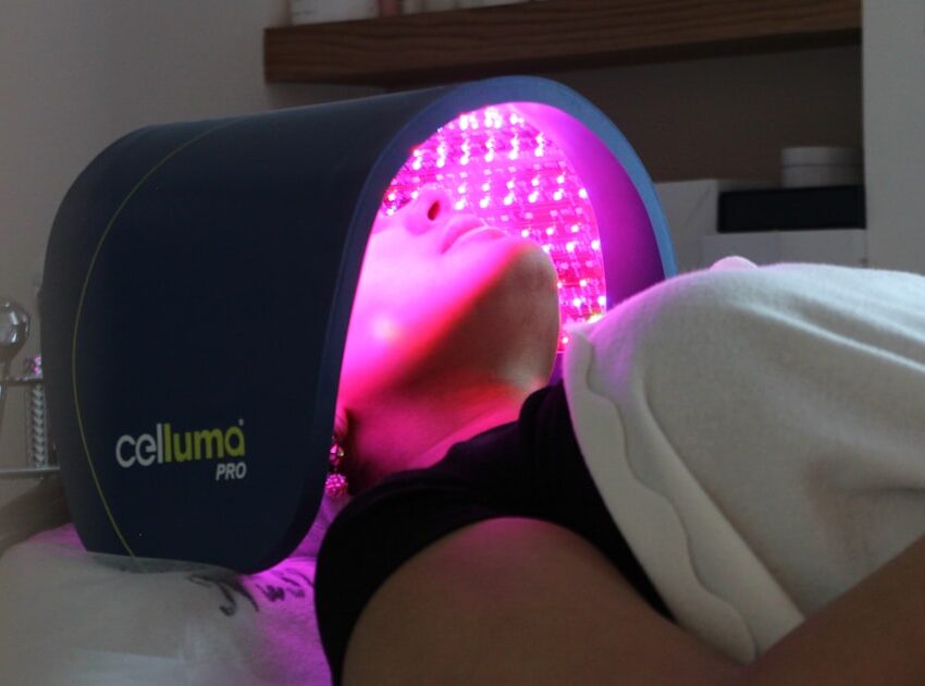 LED light therapy panel glowing over a face during treatment, the clinic version of an LED face mask for acne