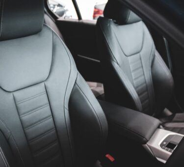 Front car seats in a vehicle interior, where a massage cushion for car seat use straps on