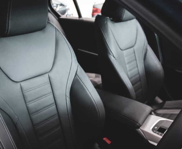 Front car seats in a vehicle interior, where a massage cushion for car seat use straps on