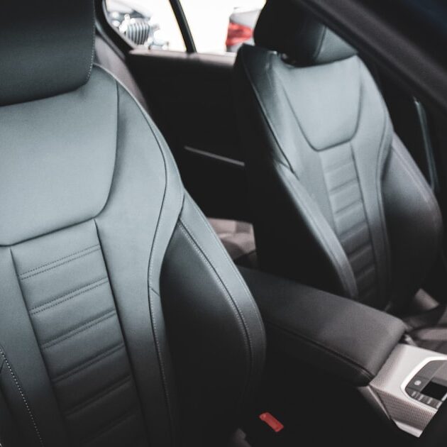 Front car seats in a vehicle interior, where a massage cushion for car seat use straps on