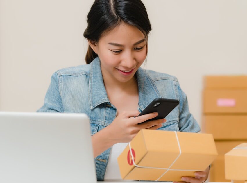 Online shop owner checking an order beside a laptop, the business deciding between Shopify vs WordPress AI e-commerce tools