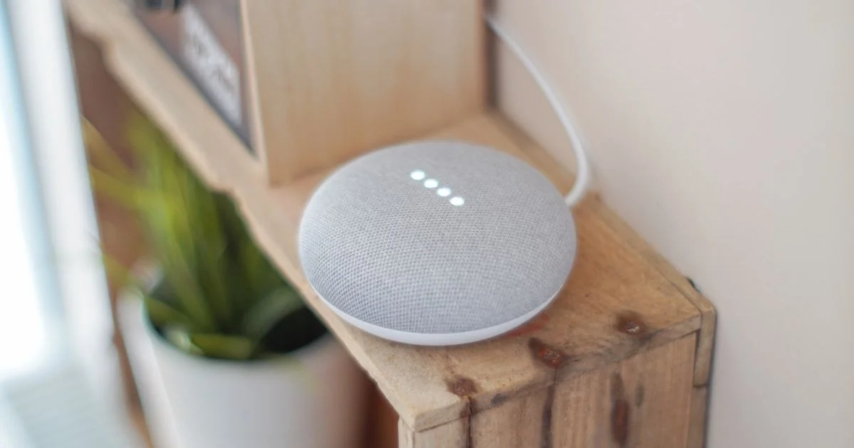 A compact smart speaker acting as a smart home hub for beginners on a wooden shelf