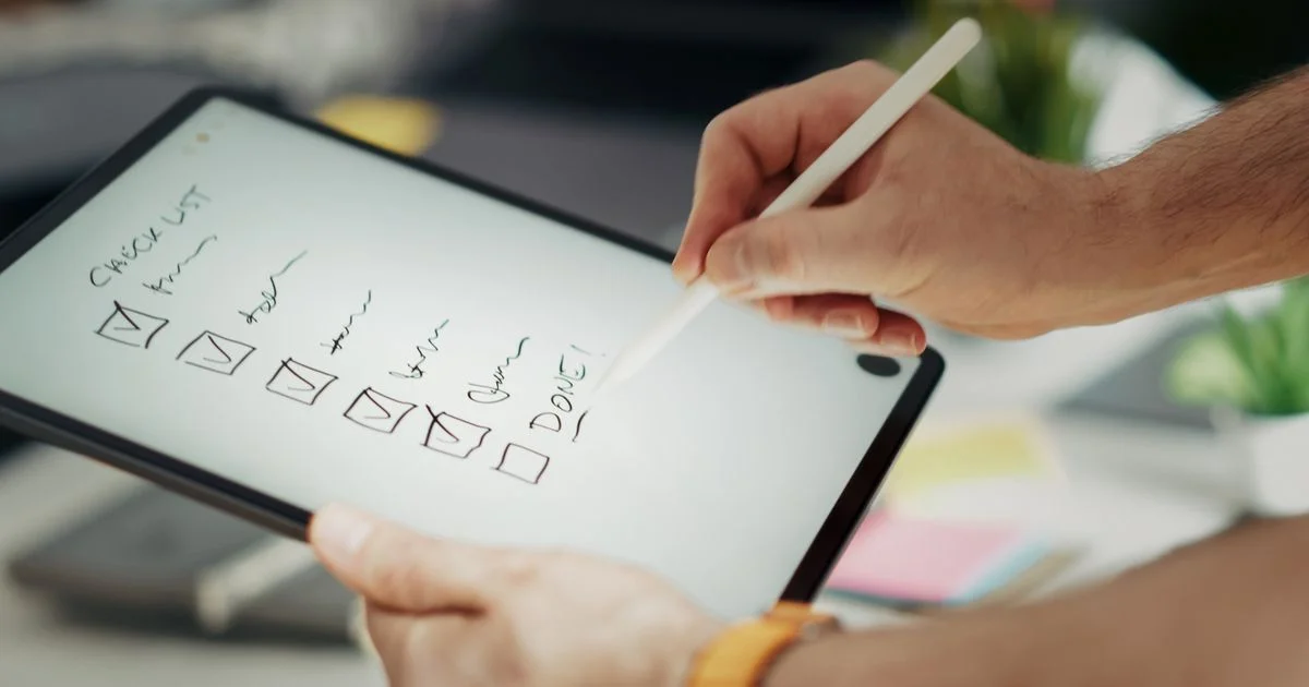 Person checking off items on a digital to do list app on a tablet with a stylus