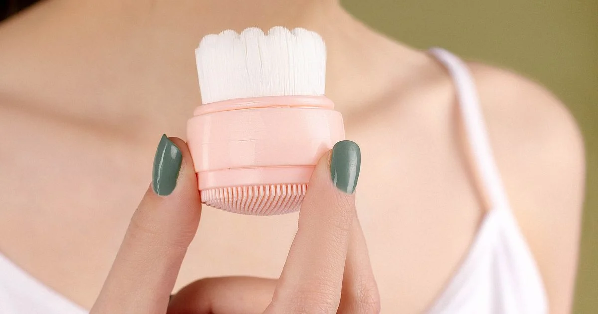 A dual-sided facial cleansing pad with soft bristles on one face and silicone nubs on the other, the two surfaces at the center of the Foreo Luna versus Clarisonic brush comparison