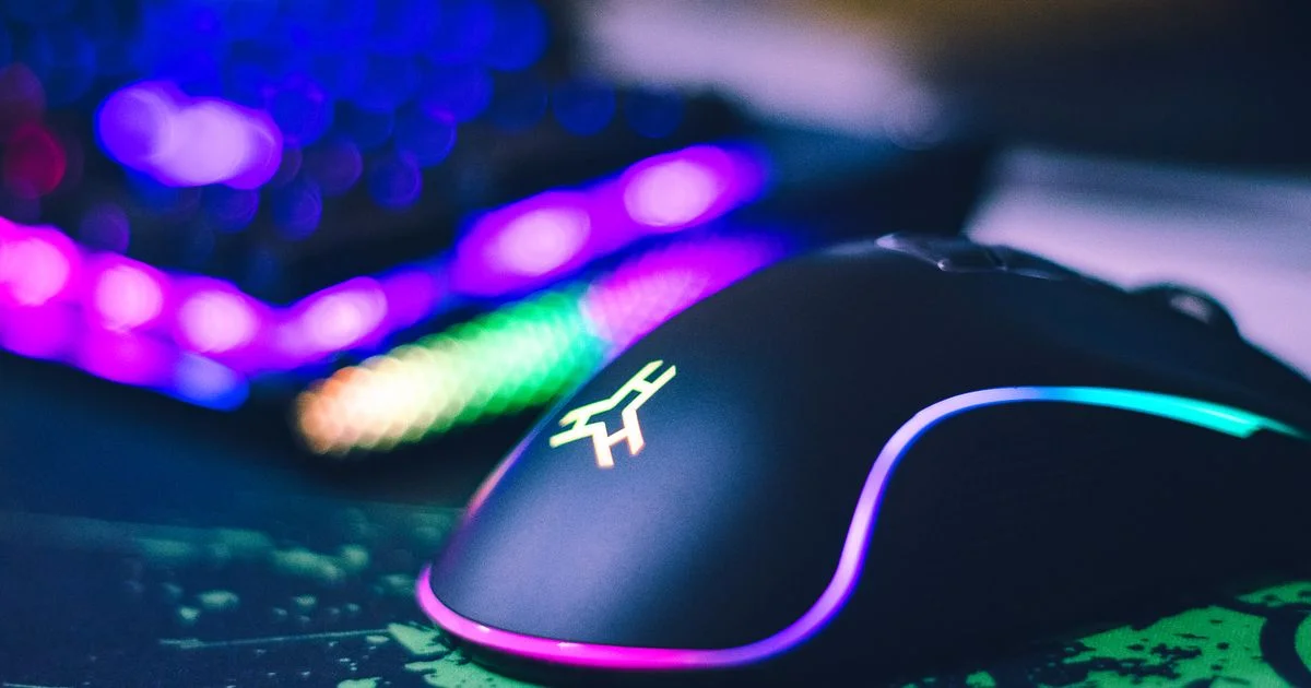 Close-up of a gaming mouse for FPS games on a mousepad, showing its shell shape and side grip