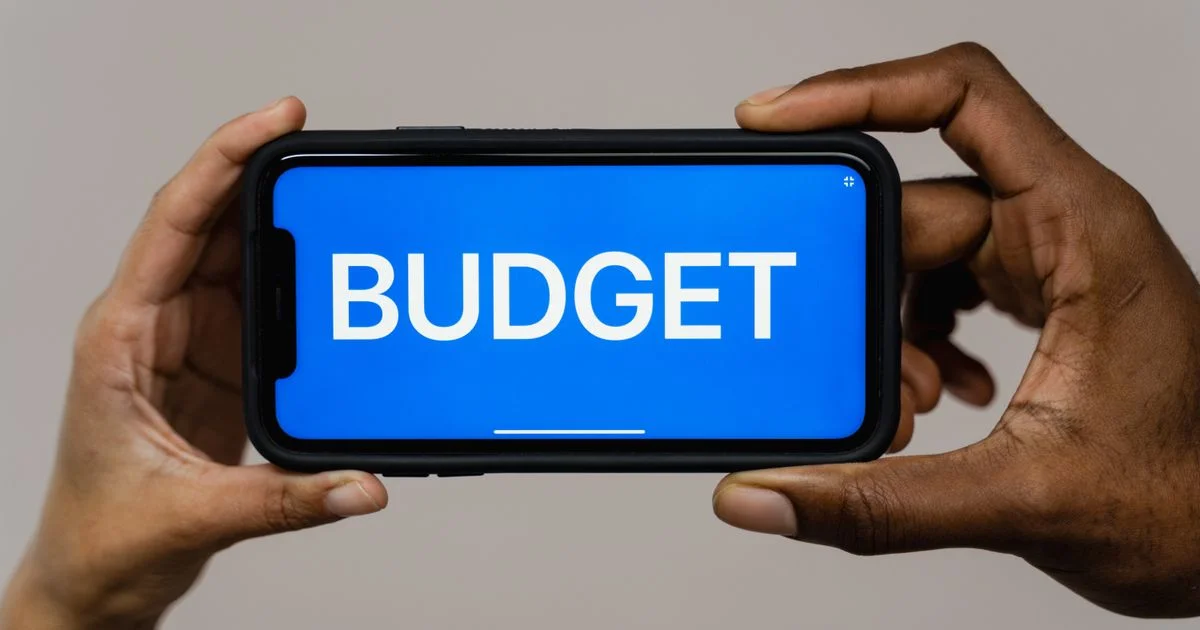 Hands holding a phone showing a budget screen, the starting point for choosing a free budgeting app for USA users