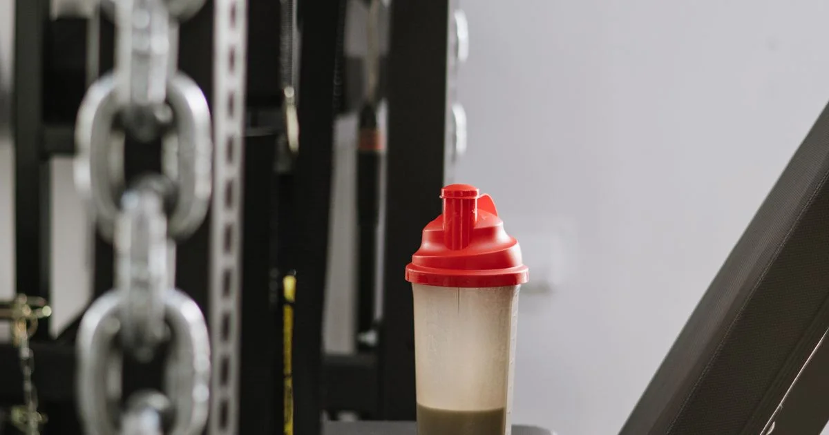 Protein shaker bottle in a gym illustrating the difference between pea protein powder and whey protein powder