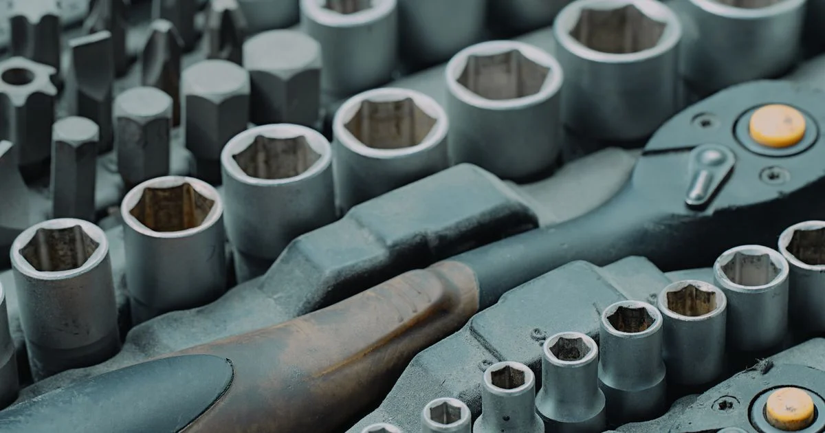A socket and ratchet set laid out in a case, the hand tool side of a Power tools vs hand tools comparison