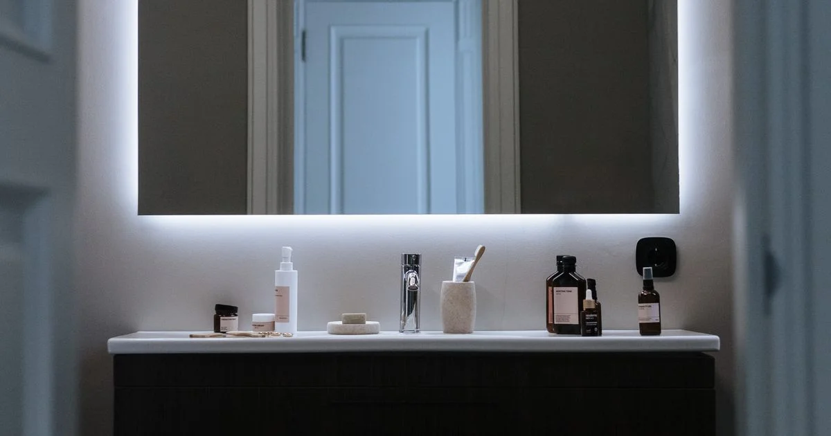 Backlit LED smart mirror for bedroom use glowing above a vanity counter