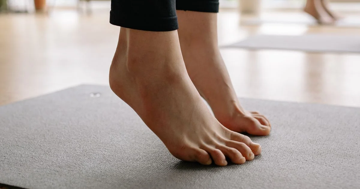Bare feet balancing on an exercise mat, the contact patch at the heart of the smart yoga mat vs regular yoga mat question