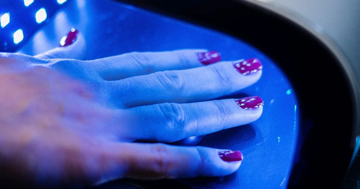 Hand curing under a lamp with a visible diode array, the modern side of a UV nail lamp versus LED nail lamp choice