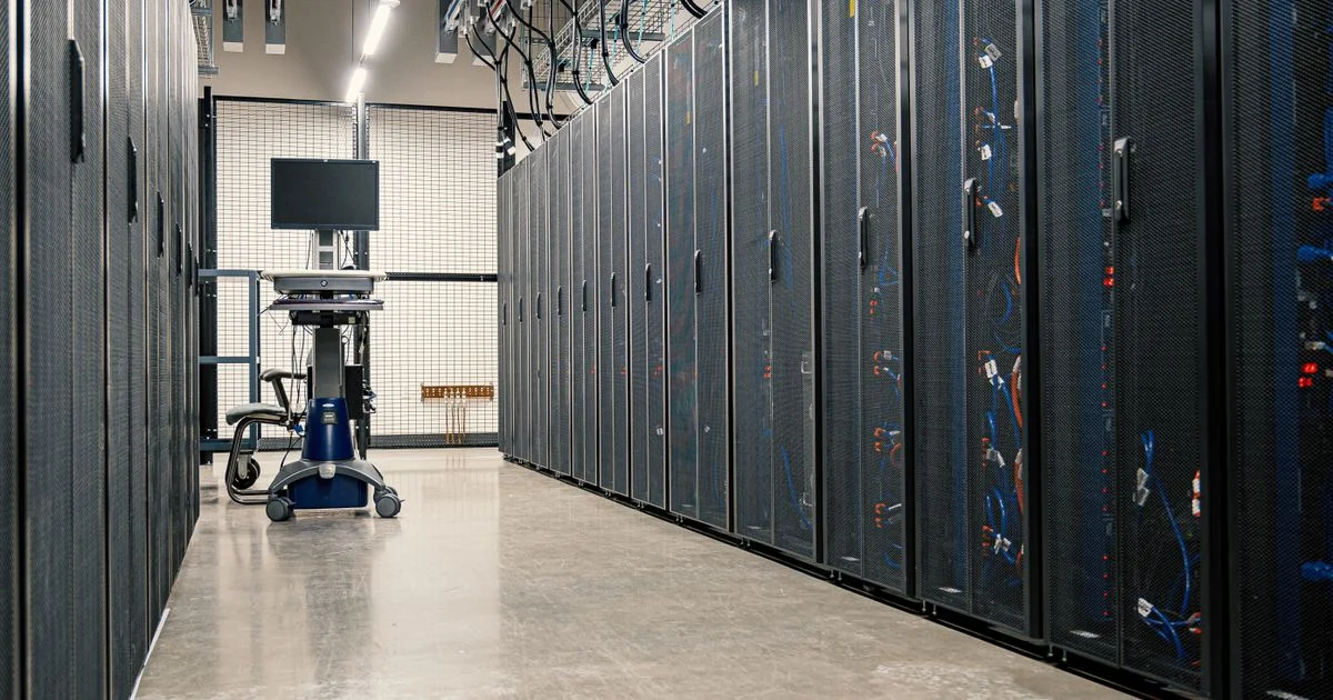 Rows of server cabinets in a data center aisle, where the address pool behind dedicated IP VPN vs shared IP VPN actually lives