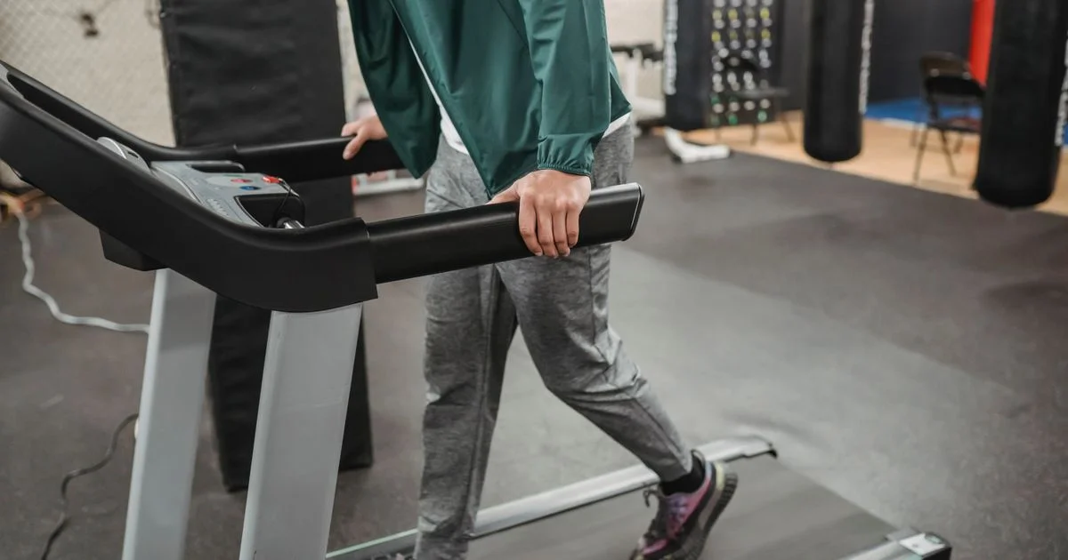 A person walking on a gym treadmill, the controlled test used for step counting in the Fitbit vs Apple Watch comparison