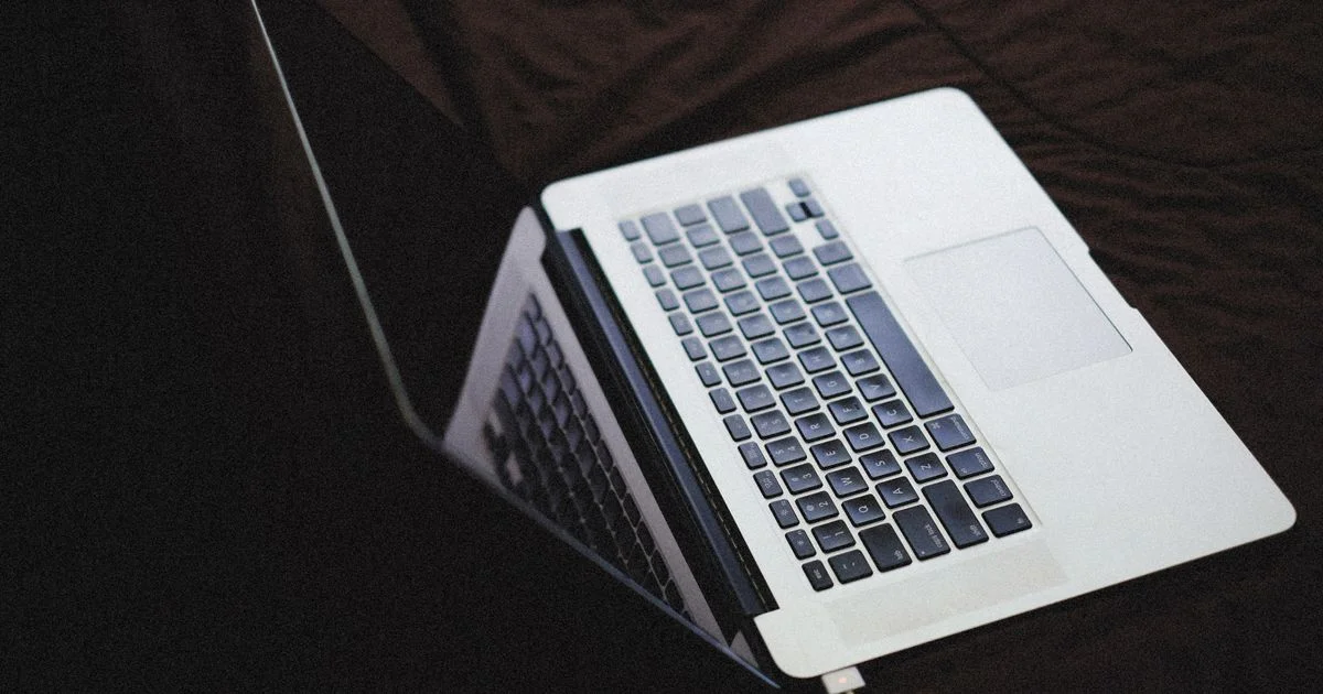 A thin laptop with its keyboard backlight glowing while plugged in, the setting switched off in the MacBook Air versus Dell XPS 13 battery tests