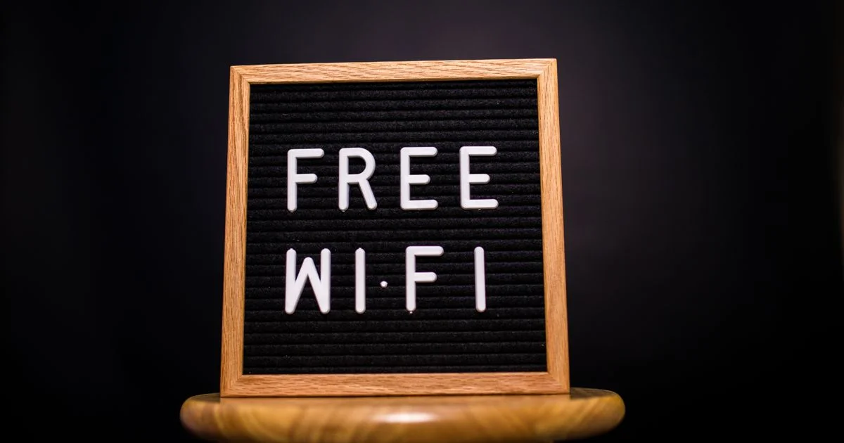 A free Wi-Fi letterboard sign on a wooden stand, the network layer at issue in the VPN vs antivirus comparison